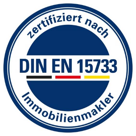 Ein kreisförmiges blau-weißes Siegel mit dem Text zertifiziert nach DIN EN 15733 Immobilienmakler und einem kleinen schwarz-rot-gelben Streifen unter der Normnummer.